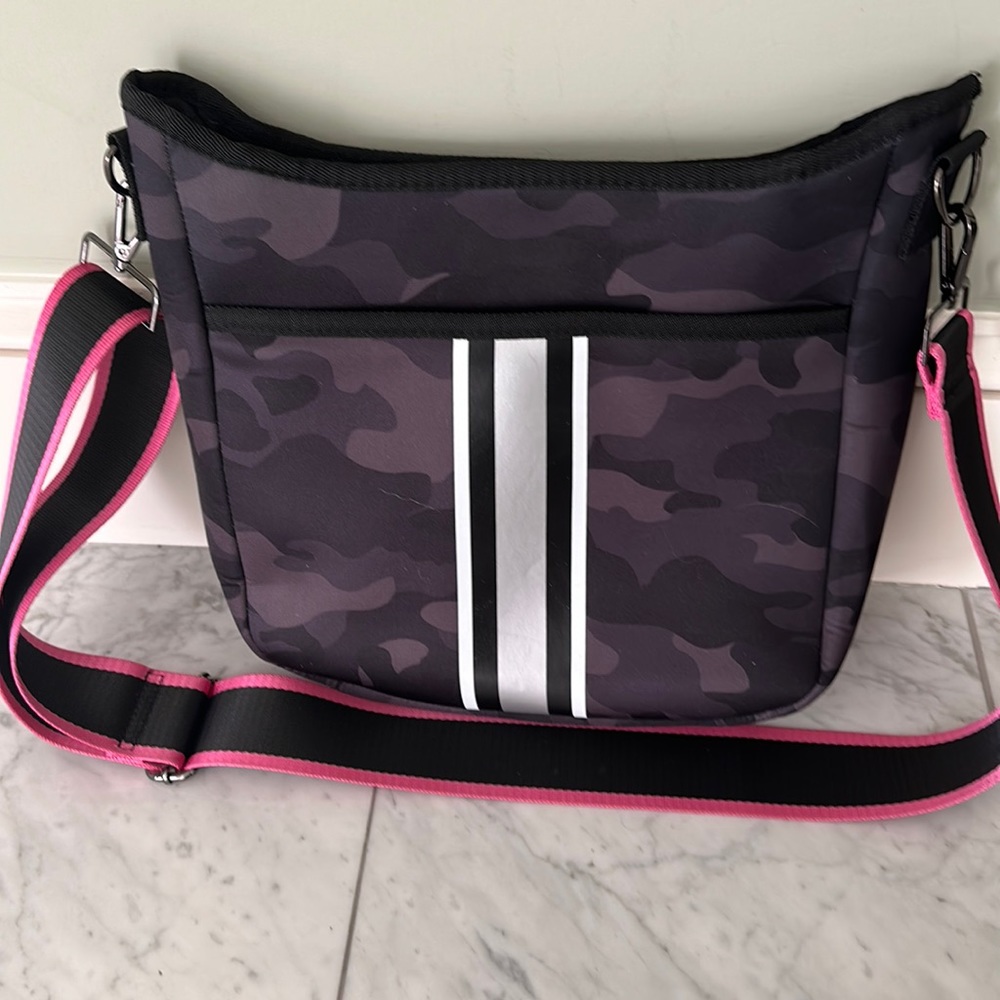 Haute Shore black camo bag with hot pink and black shoulder strap.